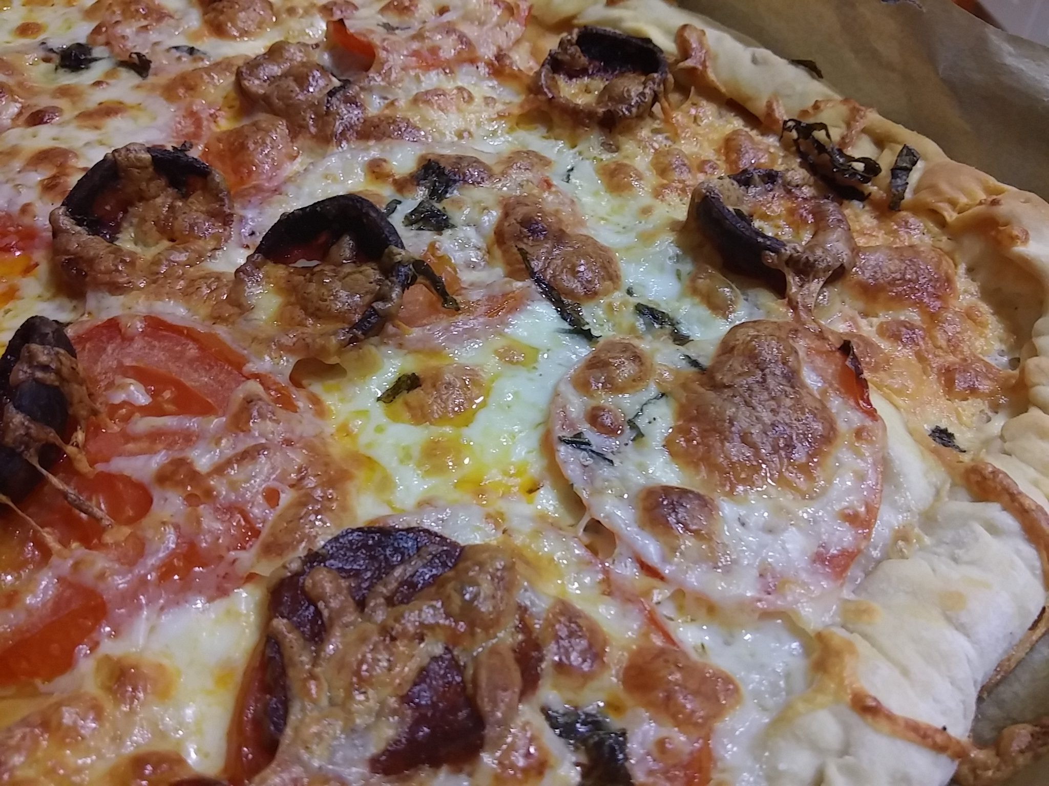 Pizza con borde de queso con tomate y chorizo.